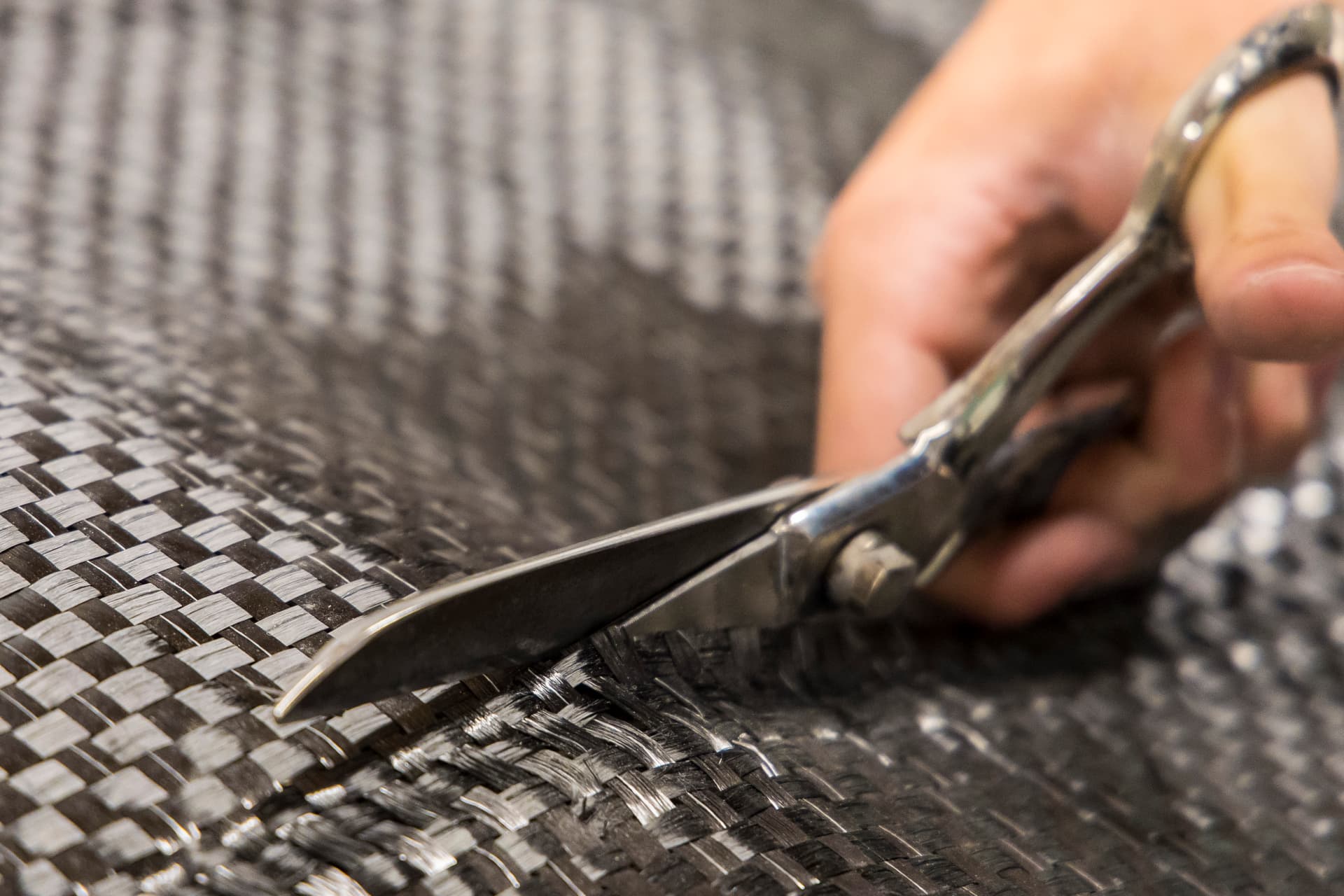 PLACEHOLDER: Technician cutting carbon fibre fabric during composite lamination