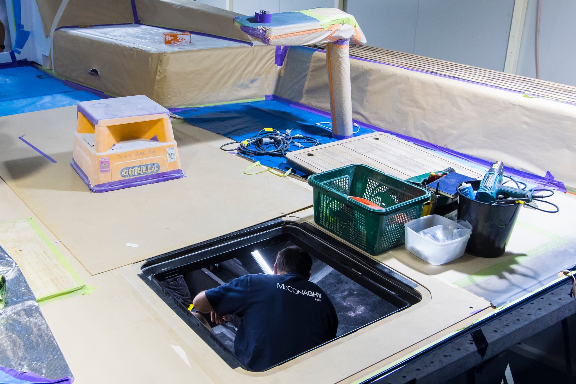 McConaghy technician working through a deck hatch during yacht fit-out at the Australian facility