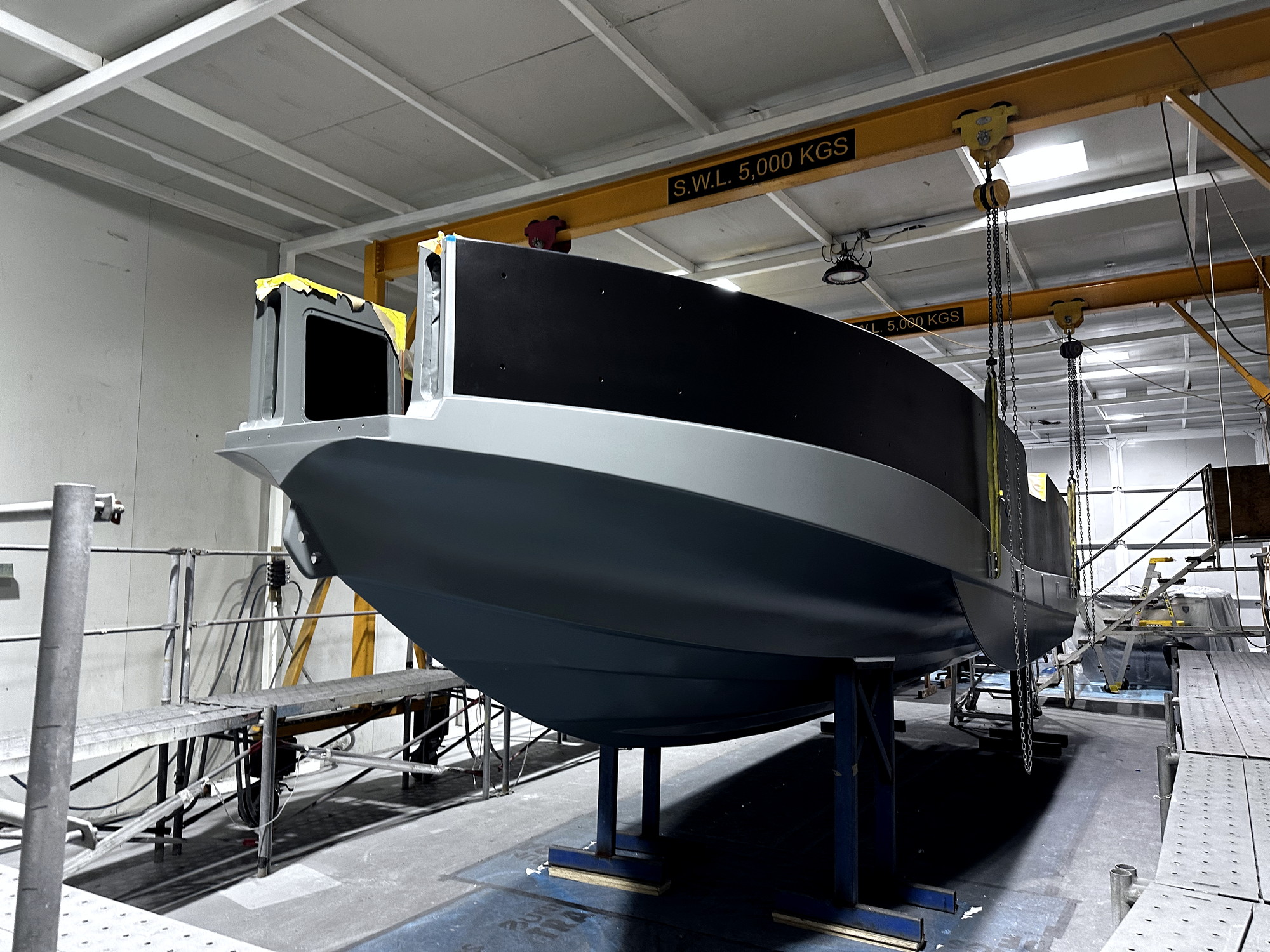 Grey composite patrol vessel hull under construction in the McConaghy Australia build hall