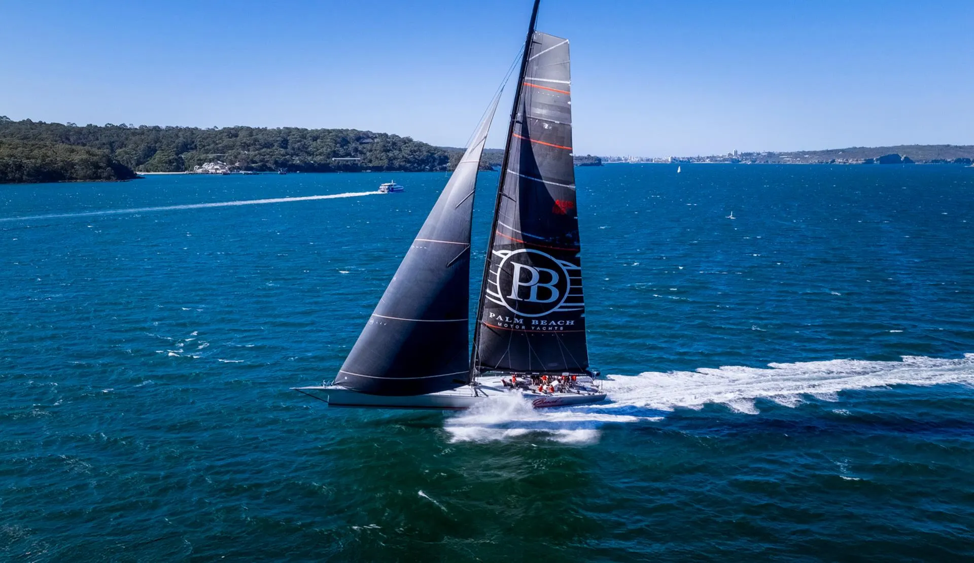 Aerial view of a McConaghy-built maxi racing yacht at speed on Sydney Harbour